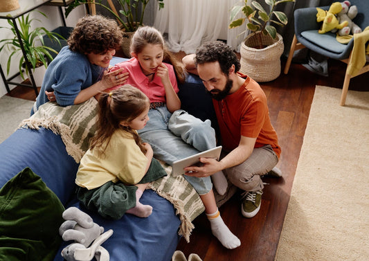 A parent and child sharing a joyful moment while watching a personalized digital gift on a tablet.